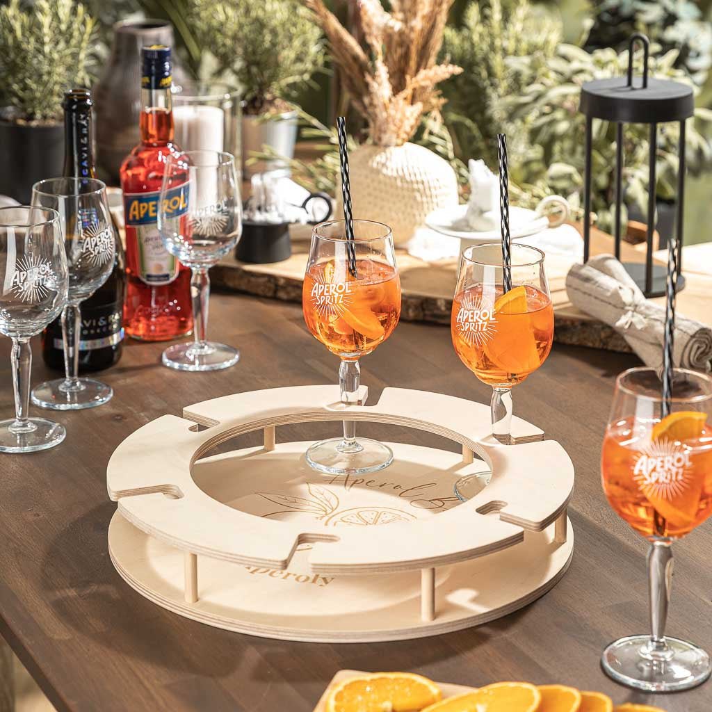 AperitifBar Valencia aus Naturholz auf einem Tisch, umgeben von Aperol-Gläsern und Flaschen im Freien.