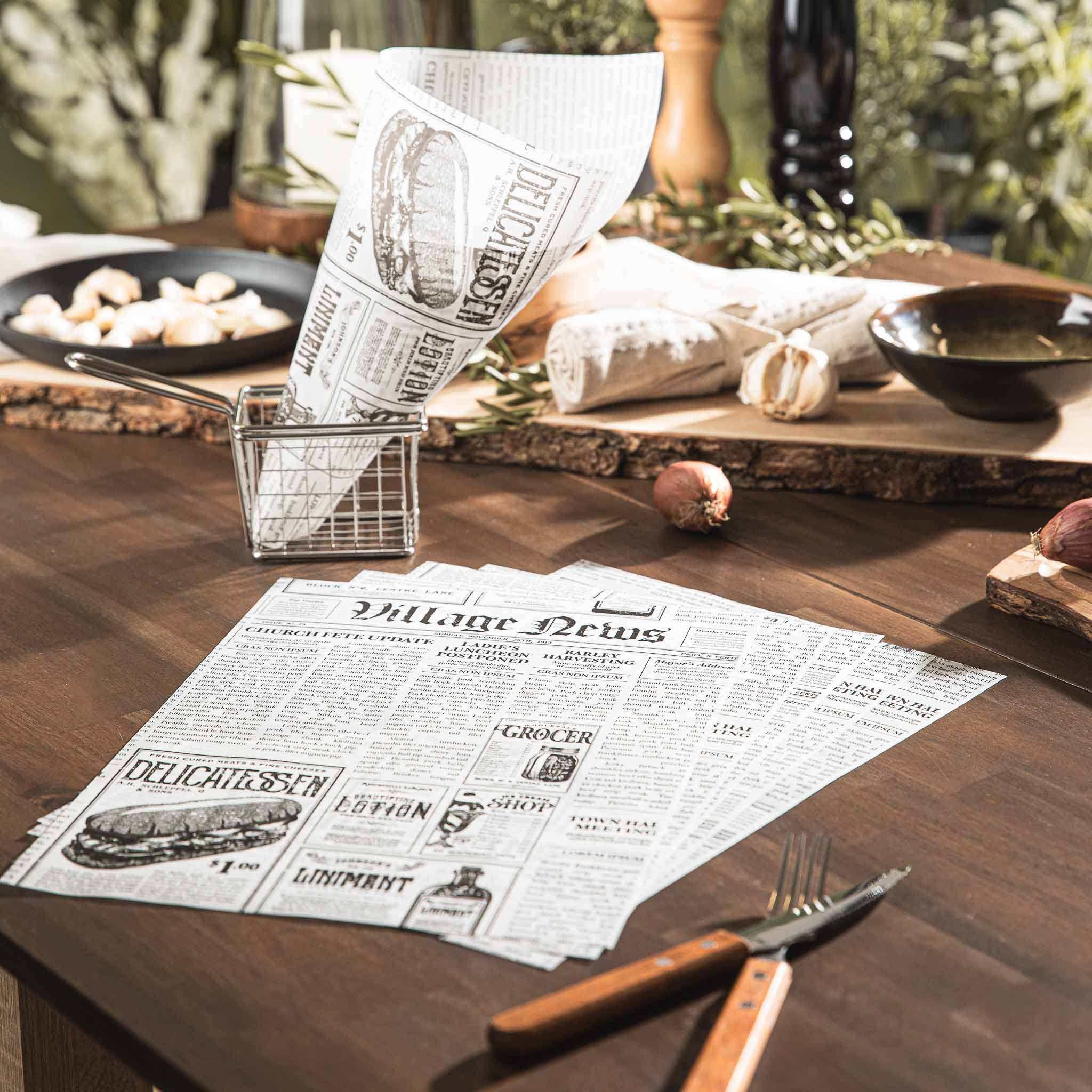 HOTTY Snackpapier in Zeitungsoptik auf einem Holztisch mit Snacks und Besteck.