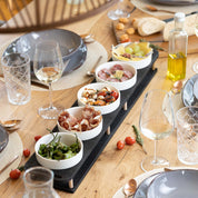 HOTTY TapasBar with ceramic bowls on wooden board, perfect for organized serving at dinners.