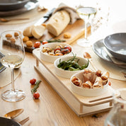HOTTY TapasBar with ceramic bowls in a wooden tray, surrounded by tapas on a dining table.