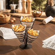Pommestütenhalter aus schwarzem Metall mit drei Fächern, gefüllt mit Pommes Frites auf einem Holztisch.