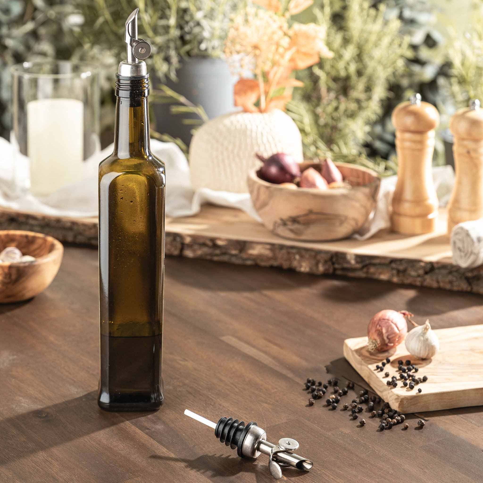 Elegant self-closing pourer on a dark glass bottle, ideal for precise dispensing of oil, spirits, and syrups, complements any kitchen or bar setting.