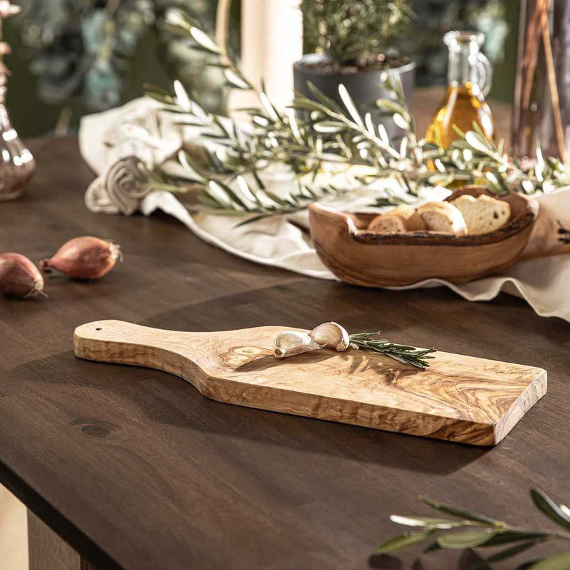 Schneidebrett aus Olivenholz mit Griff auf einem Tisch, einzigartiges Design, mit Olivenöl veredelt.